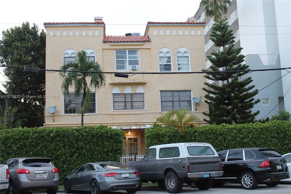 Front view of a three-story building with a beige exterior and architectural detailing.