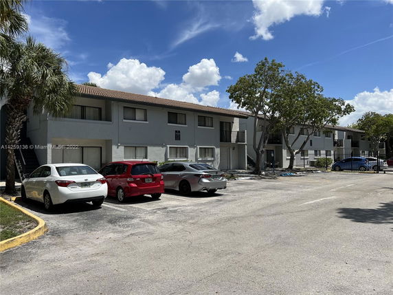 Outdoor parking area in front of a multi-story residential building.