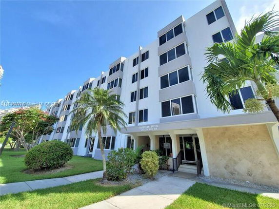 Front view of a multi-story residential building with multiple windows and an entrance.