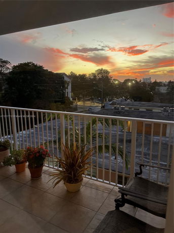 View of surrounding areas with trees and buildings seen from a balcony
