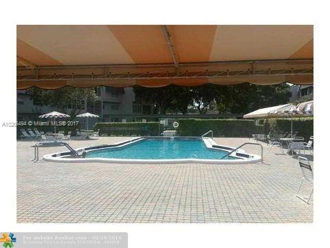 Outdoor swimming pool with surrounding deck chairs and umbrellas.