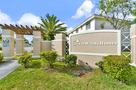 Entrance sign and entranceway of Cedar Woods Homes complex.