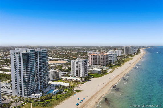 Aerial view of beachfront high-rise buildings with a coastline.