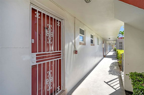 Exterior hallway leading to entrances of apartment units.