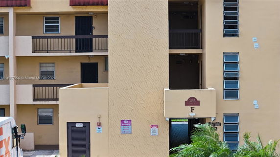 Front view of a multi-story building with balconies and multiple windows.