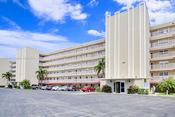 Front view of a multi-story apartment building with balconies.