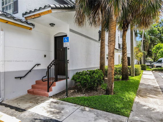 Front view of a building entrance with steps and handrails.