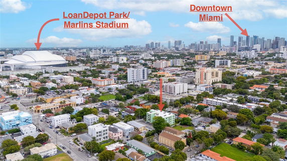 Panoramic view of a cityscape highlighting a stadium and skyscrapers in the distance.