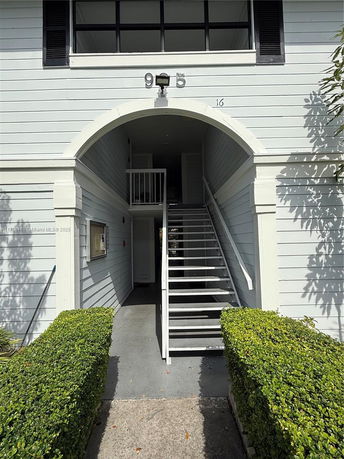 Front view of a building with a central archway and exterior staircase.