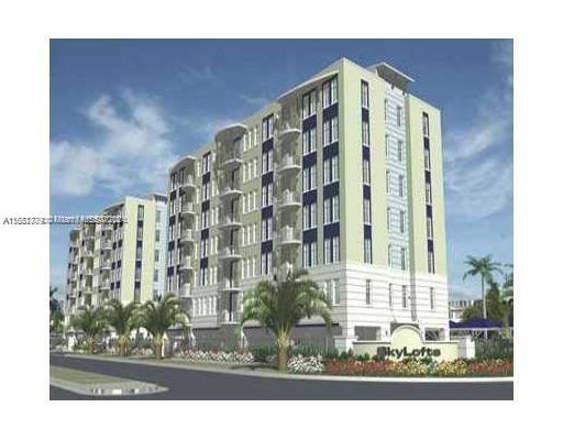 Front view of a multi-story apartment building with balconies and landscaped surroundings.