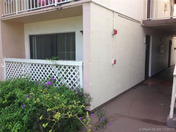 Front view of a building with a small balcony and lattice fencing near the ground level.