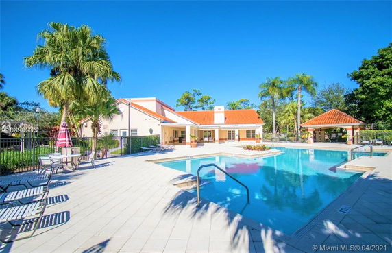 Outdoor swimming pool area with surrounding patio and adjacent building.
