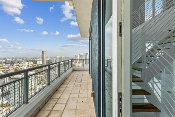 Panoramic view of cityscape from a high-rise building balcony.