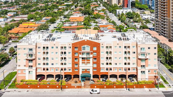 Front view of a multi-story residential building with a symmetrical design and balconies.