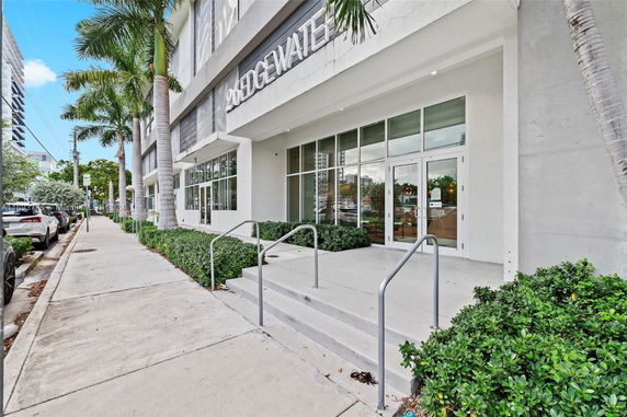 Front view of a building entrance with steps and glass doors.