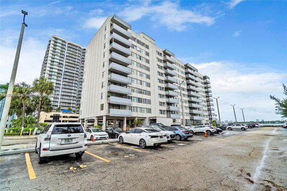 Outdoor parking area in front of a multi-story residential building.