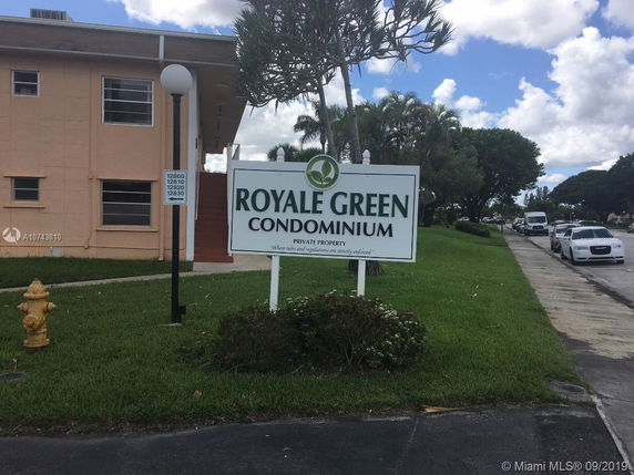 Front view of a condominium building with signage.