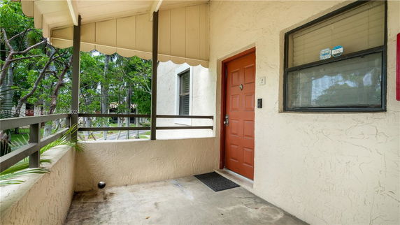 Exterior view of a house with a red door and a small porch area