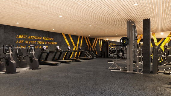 Interior of a modern gym with exercise equipment and motivational wall art.