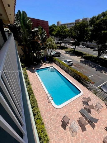 View of an outdoor swimming pool with surrounding seating area.