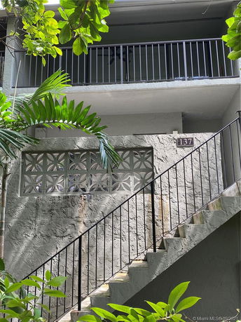 Front view of a building with an outdoor staircase and balcony.