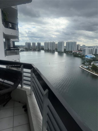 Panoramic view from a high vantage point over a body of water with several high-rise buildings in the distance.