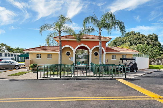 Front view of a small building with an arched entrance and red-tiled roof.