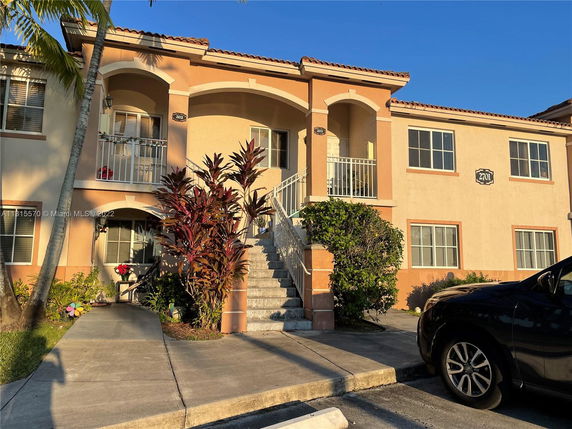 Front view of a two-story building with a staircase and balcony.
