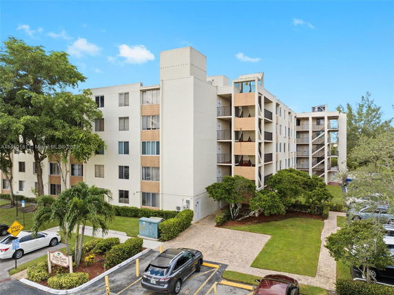 Front view of a multi-story apartment building with balconies and multiple windows.