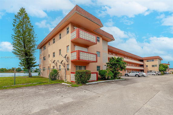 Front view of a three-story apartment building with balconies.