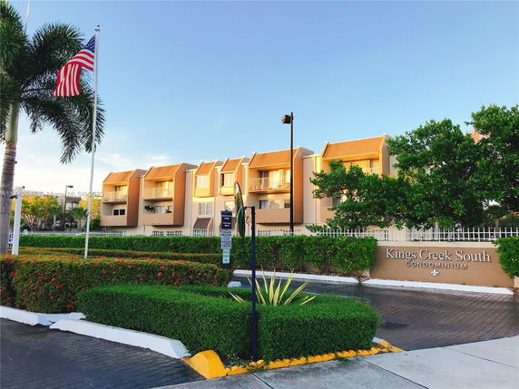Front view of a multi-story condominium building with balconies.