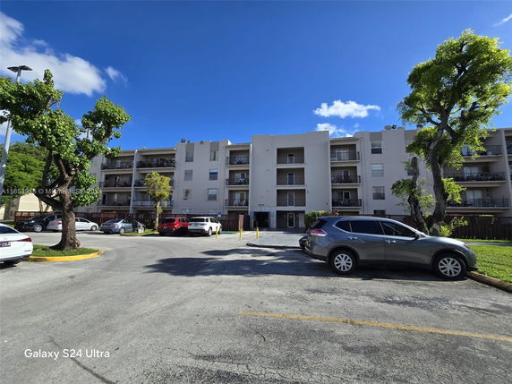 Outdoor parking area in front of a multi-story residential building.