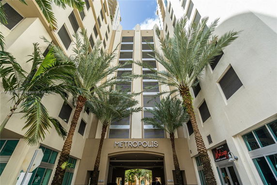 Front view of a high-rise building with palm trees and an entrance labeled 'Metropolis'.