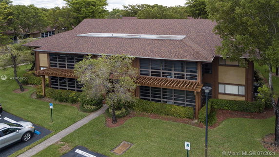 Front view of a two-story building with large windows and a shingle roof.