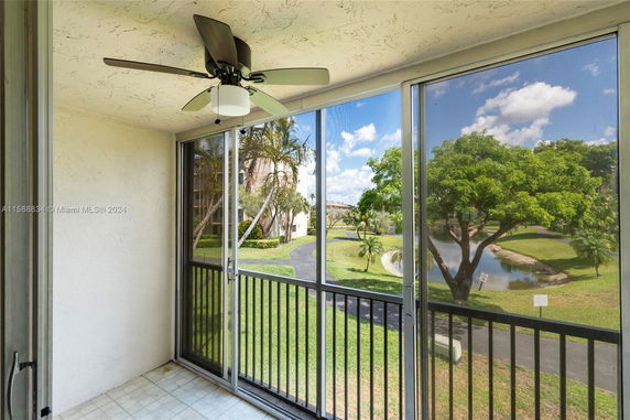 View from a balcony overlooking trees and a water body.
