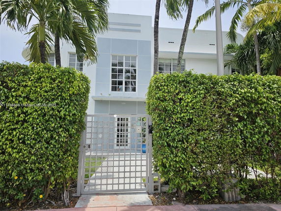 Front view of a two-story modern building with large windows and a gated entrance.
