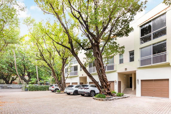 Front view of residential building with multiple garages and parked cars.