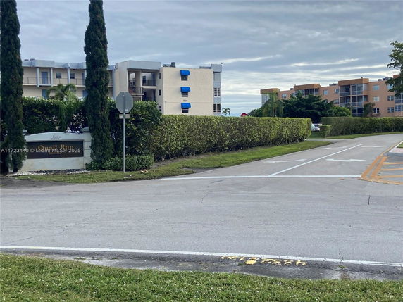 View of residential buildings with blue awnings and a sign reading 'Quail Run.'
