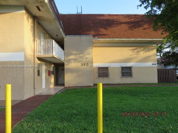 Front view of a two-story building with a balcony and sloped roof.