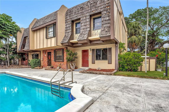 Front view of a two-story house with a swimming pool.