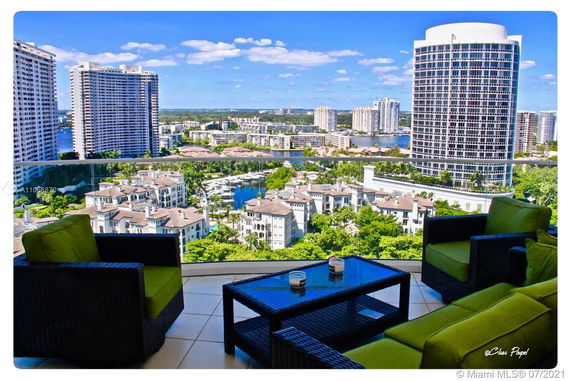 Panoramic view from a balcony overlooking modern high-rise buildings and a marina.