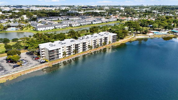 Aerial view of a lakeside apartment complex with surrounding suburban developments.