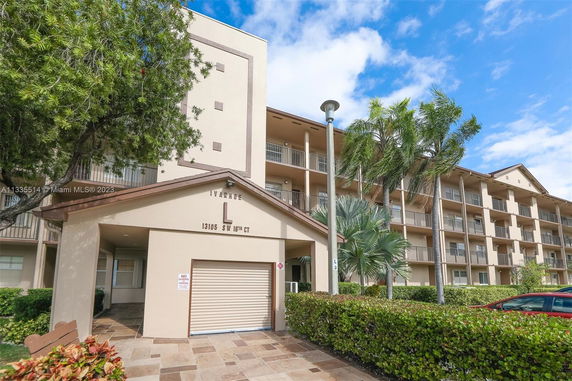 Front view of a multi-story building with balconies and a covered entrance.