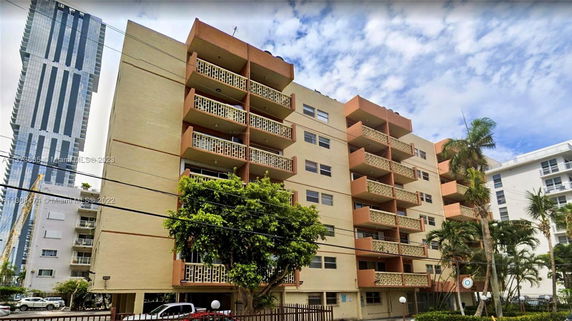 Front view of a multi-story apartment building with balconies.