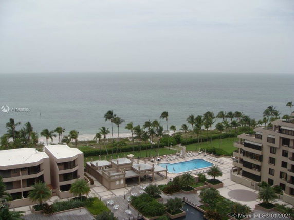 Panoramic view of a coastal area with a swimming pool and several buildings overlooking the ocean.