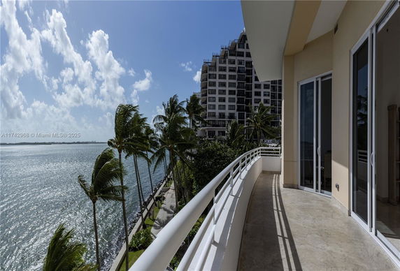 Balcony view of ocean and nearby high-rise building.