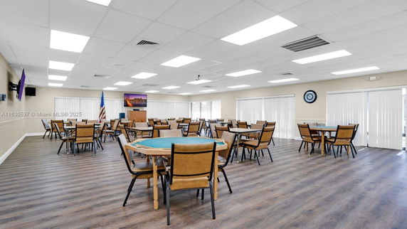 Spacious interior room with multiple tables and chairs arranged for recreational activities.
