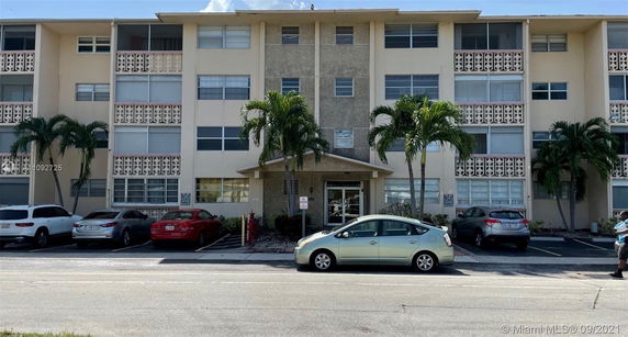 Front view of a multi-story residential building with parking spaces
