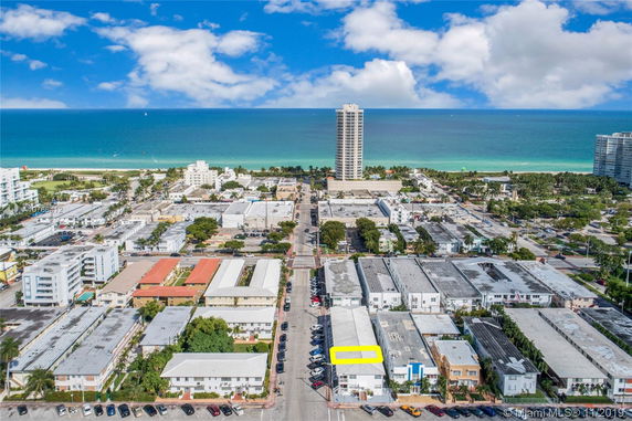 Aerial panoramic view of a coastal cityscape with the ocean in the background.