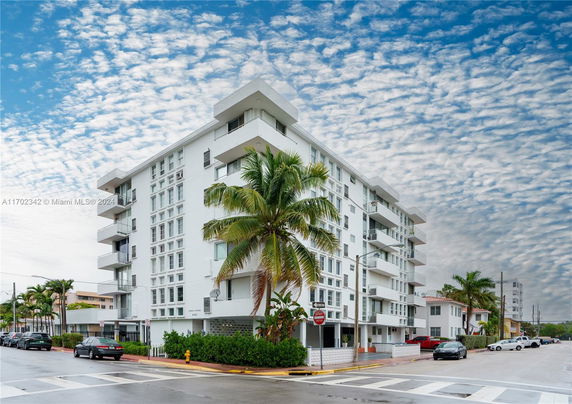 Front view of a multi-story residential building on a street corner.